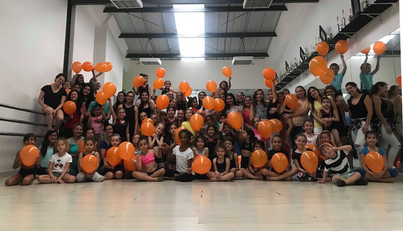 Bambini in possesso di palloncini arancioni