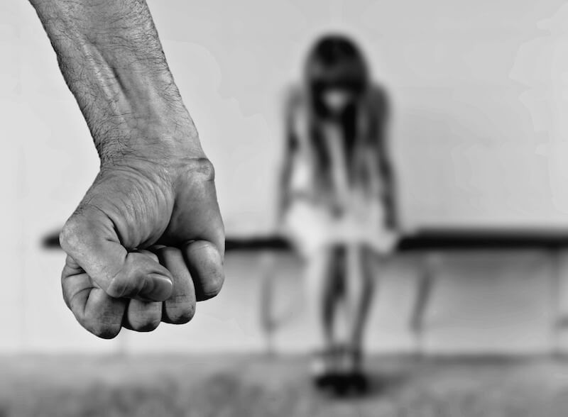 pugno chiuso e ragazza spaventata in background